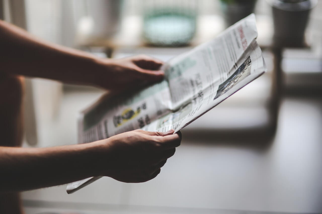 Close up of a person holding a newspaper